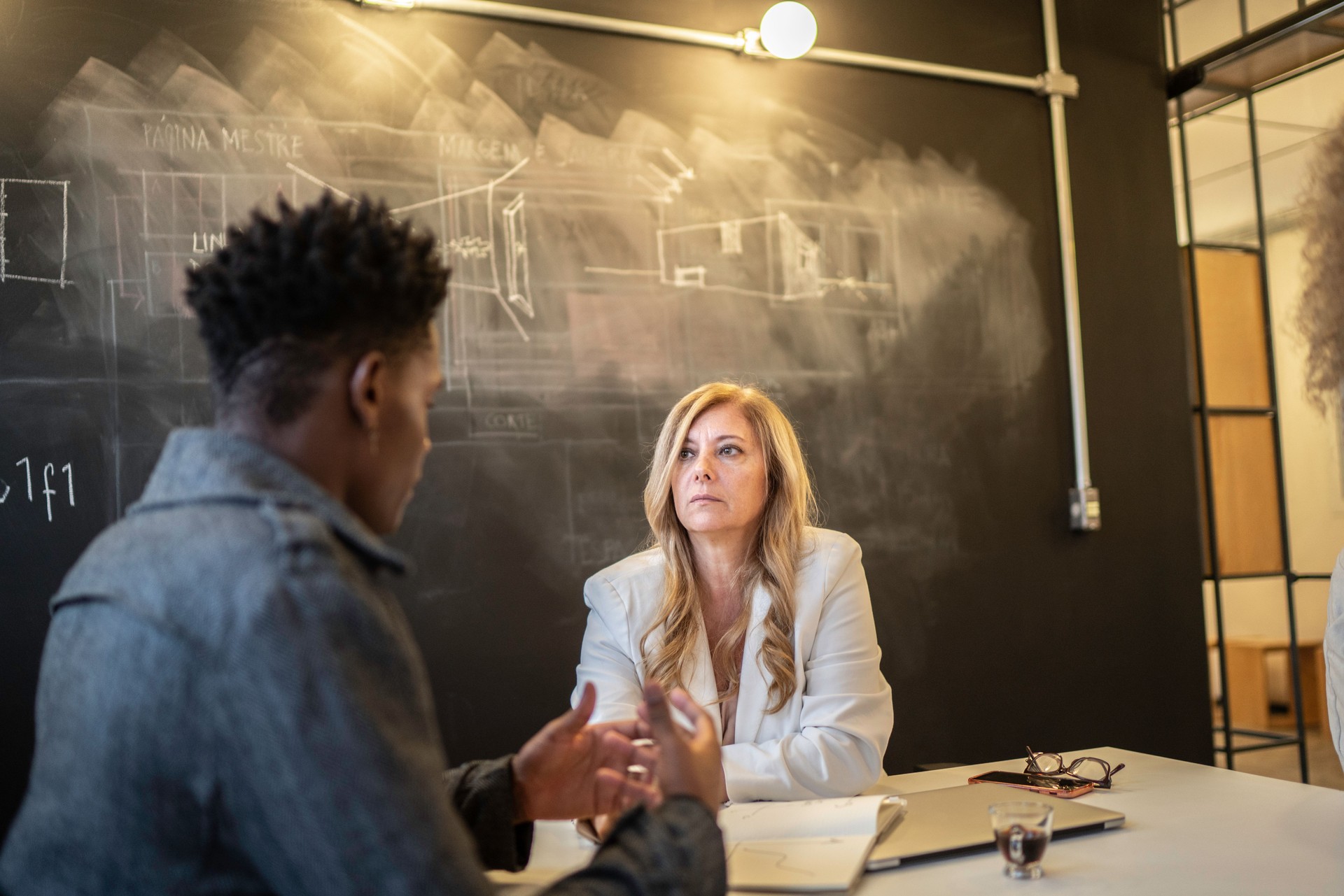 Businesswoman giving advice to employee at room